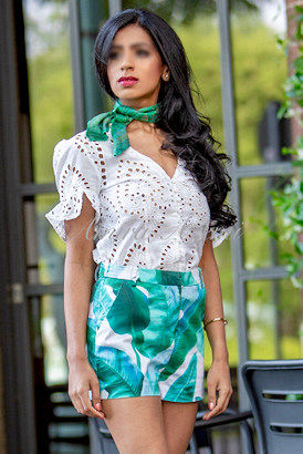 British Asian independent escort in a short flower pattern skirt and white top