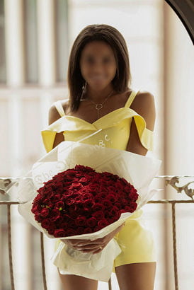 Beautiful black girl in a yellow dress holding a big bouquet