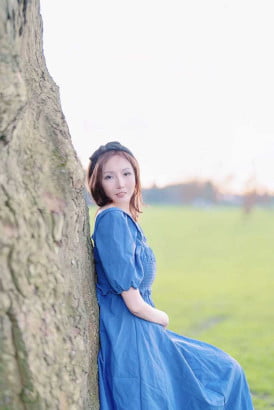 Fair skin South Korean girl leaning against a tree