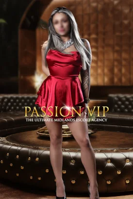 Petite blonde girl with tattooes on her arms wearing a short red dress