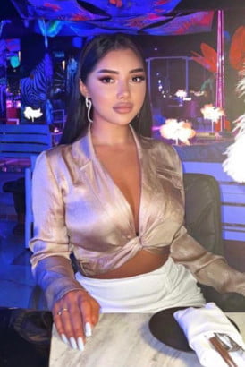 A young busty Turkish girl sitting in a restaurant